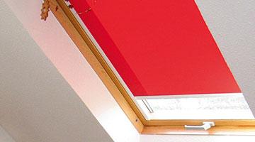 Dachfenster Rollo in rot mit manuelle Bedienung
